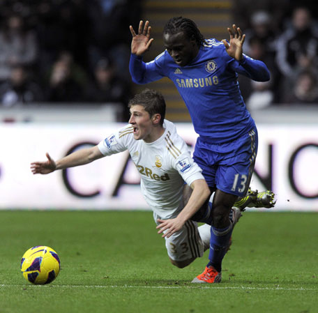 Ben Davies (L) challenges Chelsea's Victor Moses