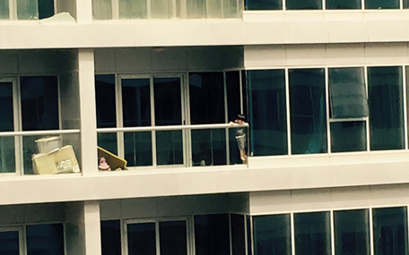A child throwing a toy over the balcony