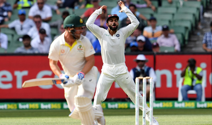 Virat Kohli (R) reacts as Australia's batsman Aaron Finch